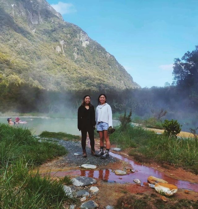 Natural hot pools at Welcome Flat Hut surrounded by mountains at sunset