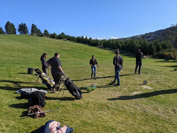 GetHomeSafe team members taking turns at the Otago Golf Club driving range
