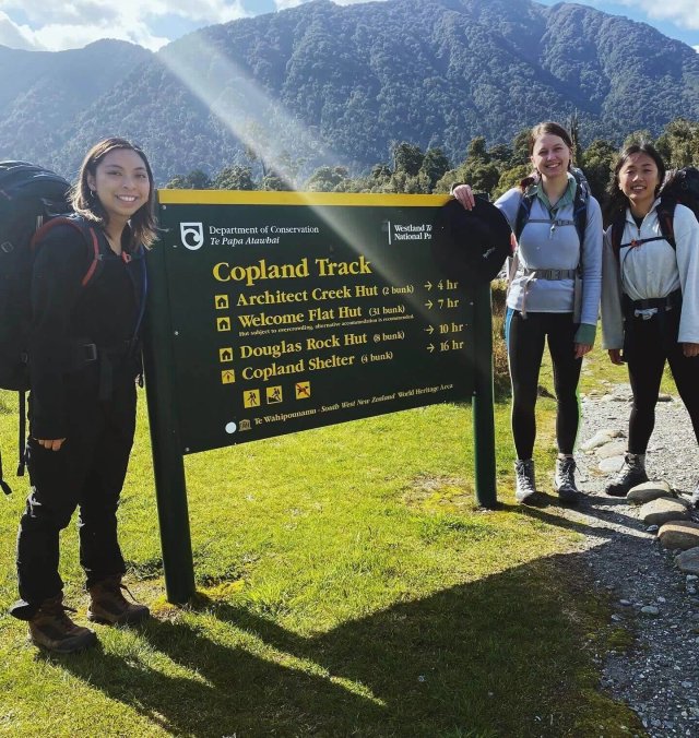 Hikers crossing a wide rocky river bed at the start of the Copland Track