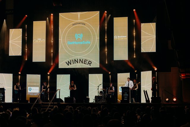 GetHomeSafe team accepting an innovation award on stage at an industry event