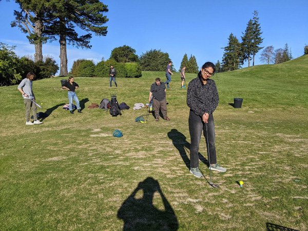 Team member practising a golf swing at the Otago Golf Club driving range