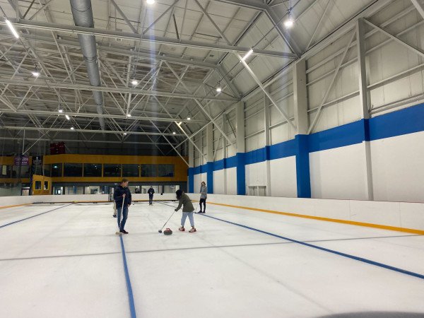 Team members curling together on the ice at Dunedin Ice Stadium